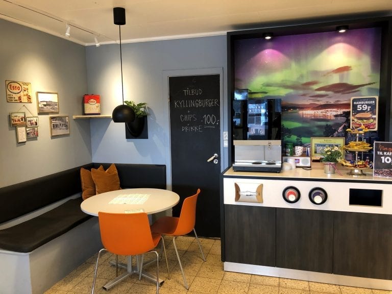 Coffee corner at the gas station, Best, with orange chair and tables and a coffee machine.