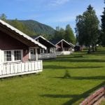 Some of the big and nice cabins at Bjerka Camping seen on a summer day surrounded by green and lively nature.