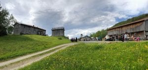 Panorama picture of Inderdalen Farm with people playing and enjoying the beautiful nature surroundings.