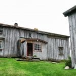 The main building at Inderdalen Farm, a beautiful, old, grey and well-kept wooden building.