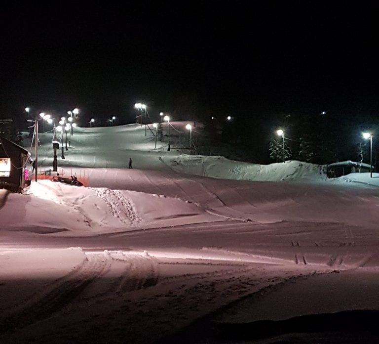 Down hill slopes in Bleikvasslia at night with only the slopes lit up in white and pink lighting.