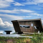 Wooden shelter with outdoor grill on top of a hill