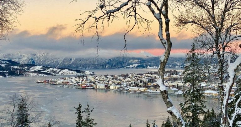 Hemnesberget, a town located next to the fjord, seen from the other side of the fjord from the mountains surrounding it.