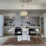 Nice big, white kitchen with a table for four people in front.