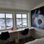 Bedroom with two big windows and a big painting on the wall