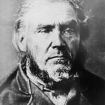 An old black and white picture of a serious looking man with half long hear and a big beard