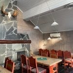Cozy restaurant room with wooden walls and red wooden furniture.