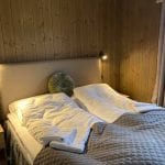 Bedroom with big double bed and wooden walls.