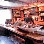 Elderly lady selling local and home-made food in one of the many beautiful old buildings at Inderdalen Farm.