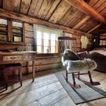 Cozy and old-style bedroom at Inderdalen Farm with a rocking chair, old desk, and bed.