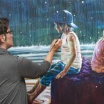 Artist, Yvonne, concentrated while painting the last touch on her painting of two kids.