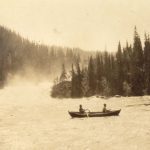 Old black-and-white picture of two people on a small rowboat on the wide river, Sjøforsen.