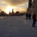 Lots of people in the skiing trails in Korgen with a burning sunset surrounding them in the sky.