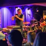 Concert at Jernvaren during the jazz festival at Hemnesberget, with the stage lit up in blue colors behind the five musicians.