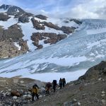 People walking in front of the glacier Austre Okstindbreen with Oksskolten in the background.