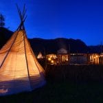 Dark blue sky, sami lavvo tents lit up on the markedplace during Klemetspelet
