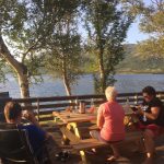 People on a bench overlooking a lake.