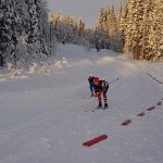 Skiers in tight skiing suits on their way down a small hill during a competition in the skiing trails in Korgen.