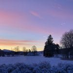 Winter landscape with a beautiful orange-pink-purple night sky.