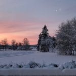 Winter landscape with an orange-pink night sky.