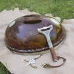Sami drum with hammer made in shining wood with sami pictograms on it.