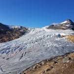 Glacier tongue at Austre Okstindbre on a summer day surrounded by bare mountains.