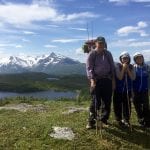 A man and two kids ready for a fishing trip at Korgenfjellet in the sun, with the Lukttinden mountain in the background.