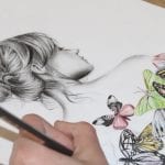 A hand drawing a young girl and colorful butterflies.