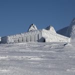 A snow-covered cabin in the mountains, “Rabothytta”, surrounded by a white landscape in all directions.