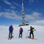 Colorful skiers on their way up to the top of the mountain, “Veten” with its characteristic tower on top.