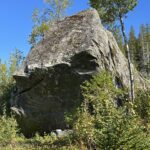 A big rock amidst trees.